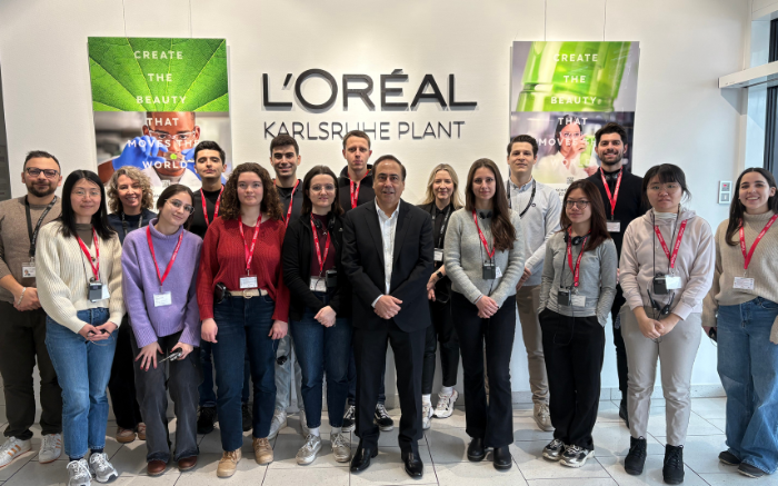 Studierende vor L'Oréal Logo