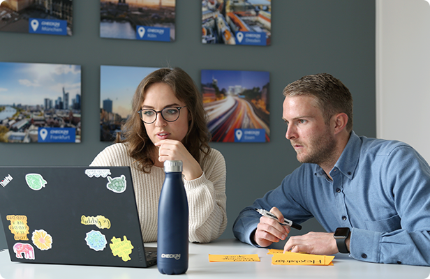 Frau und Mann sitzen vor dem Computer und diskutieren